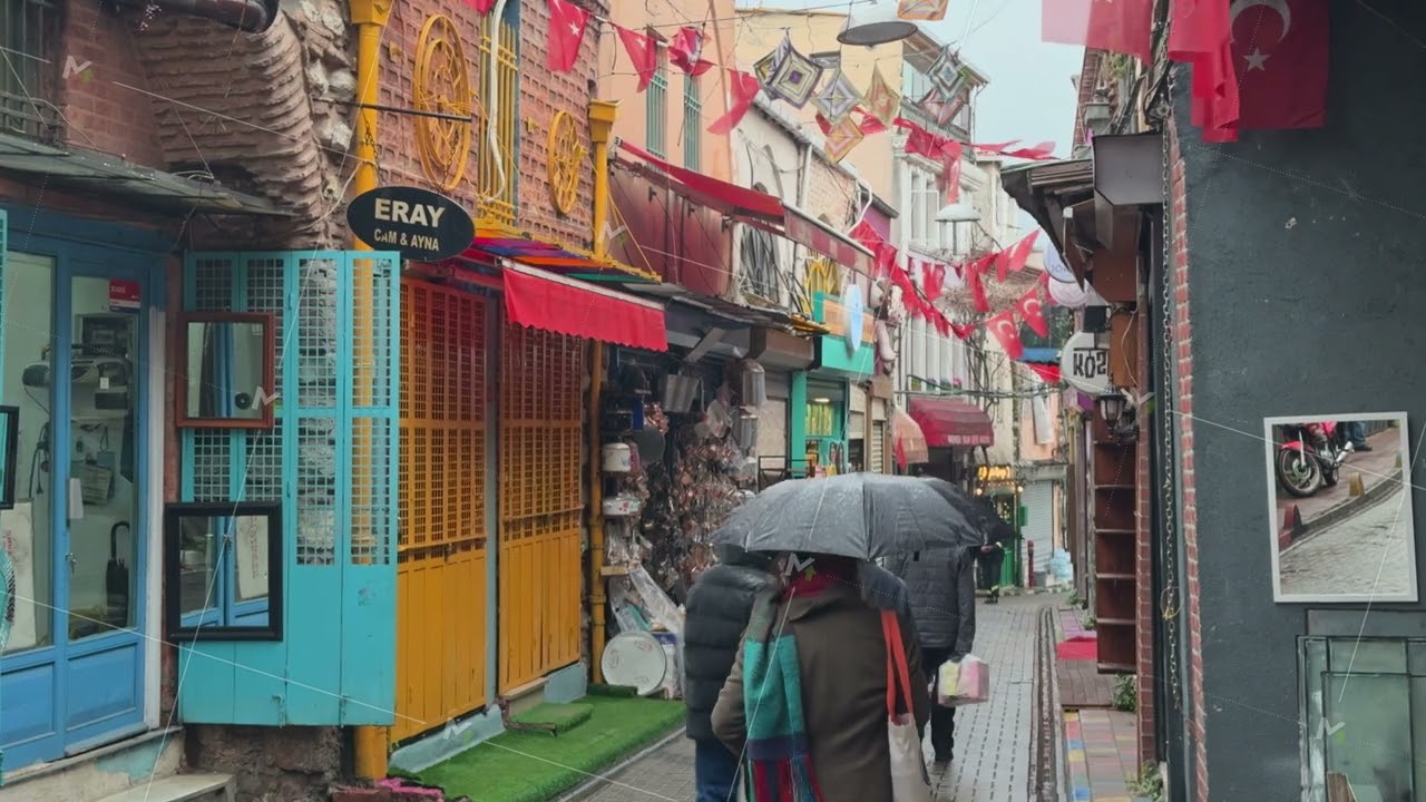 People walking in a colorful street market adorned with Turkish flags