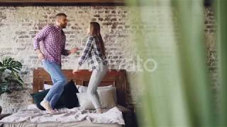 Of Happy Young Lovers Dancing On Double Bed Having Fun In Bedroom And Laughing Carelessly Cheerful