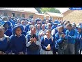 Njube High School students sing soon after their girls' rugby team.