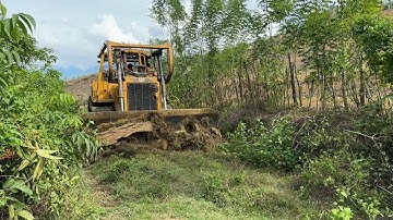 Caterpillar D6R XL bulldozer opens a new road full of stones