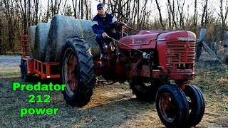 Predator 212 tractor, hauling rolls of hay.