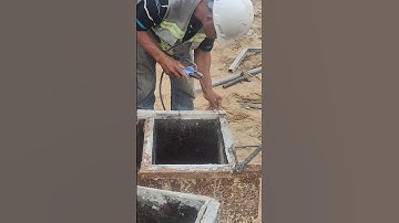 Workers welding steel plate to create footing formwork