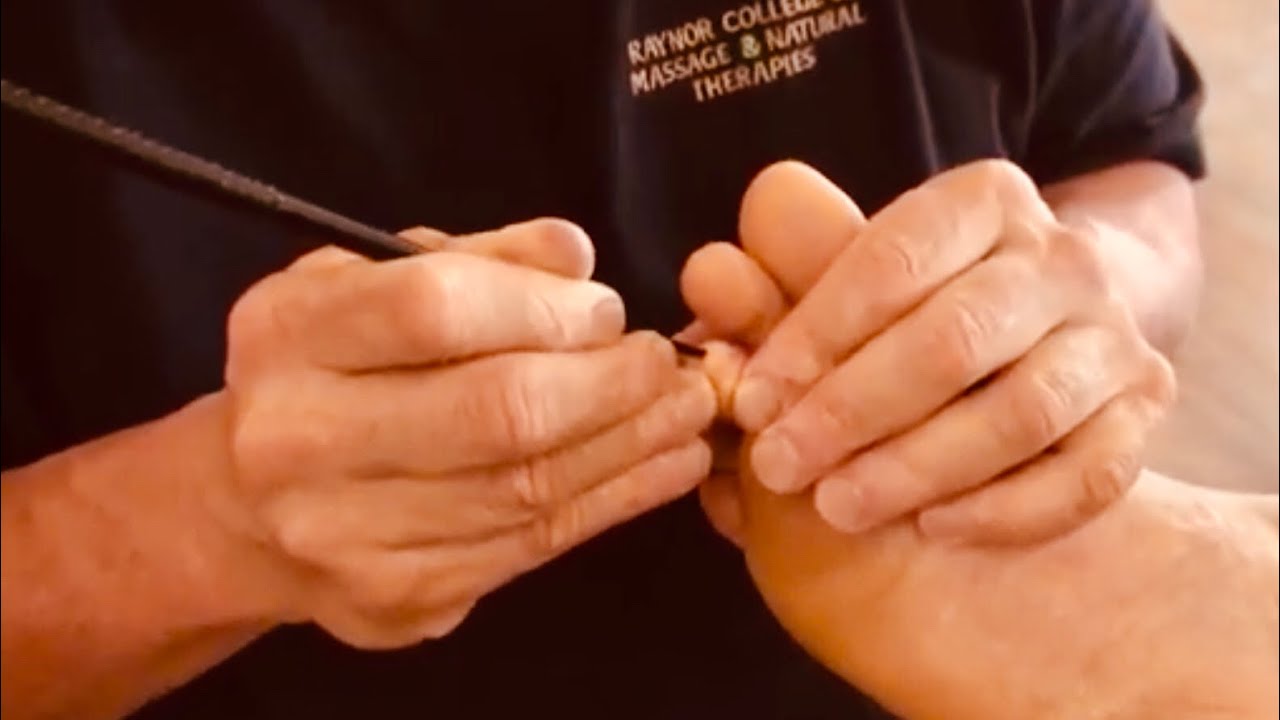 Foot massage using tools. Raynor foot reflexology using chopsticks and