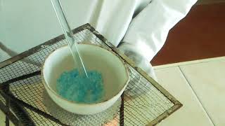 Heating copper (II) sulphate crystals.