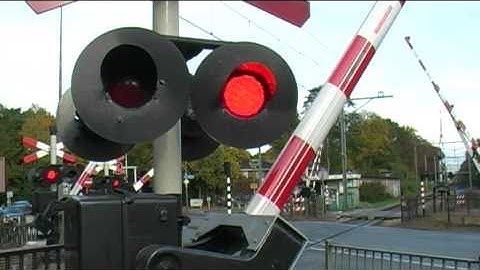 TRAIN PASSES BY VERY QUICKLY AT RAILROAD CROSSING / Spoorwegovergang in Bilthoven