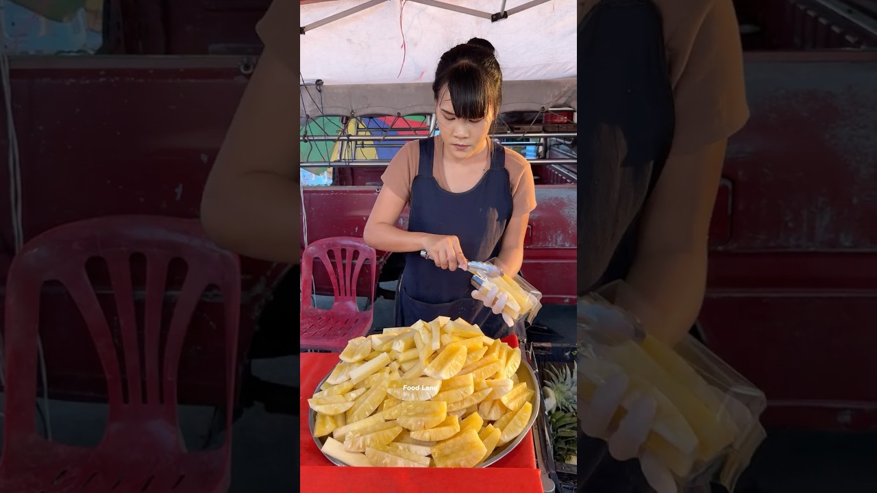 Thai girls master pineapple cutting.