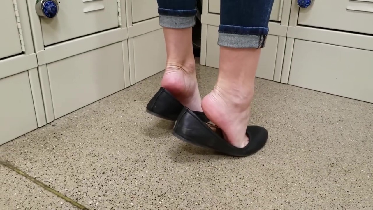 Standing a locker and popping her heels out of her Black flats heel pop #Flats #BlackFlats #Shoes