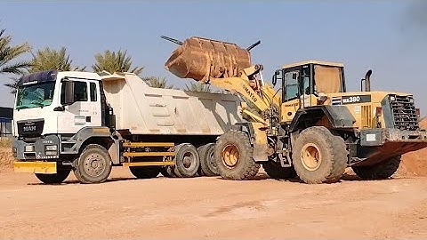 KOMATSU WHEEL LOADER WA 380.LOADING SOIL ON TRUCK.& UNLOADING THE MAN TGA 40. 400 DUMPTRUCK