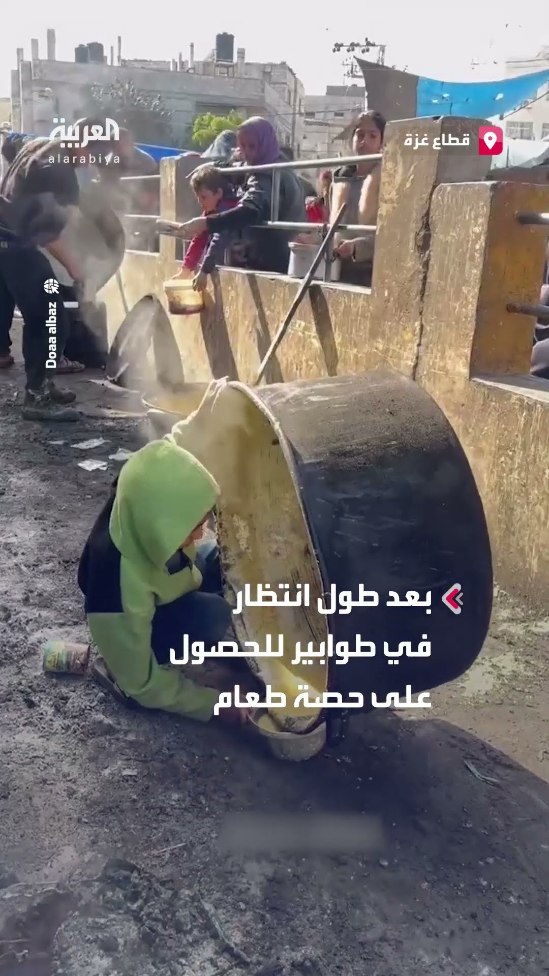 طفل يحني قدرا ضخما من الطعام للحصول على بقايا حساء في أحد التكيات بغزة