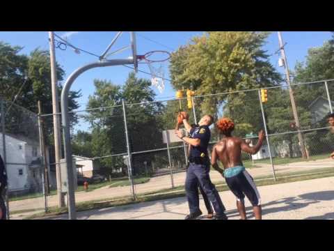 Michigan State Police Officers play basketball with teens at Saginaw Elementary Schoolyard