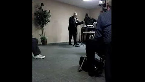Pastor Claude Spurlock preaching.