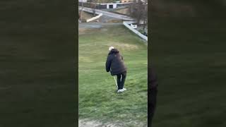 Guy rides scooter down grass hill then falls forward and faceplants