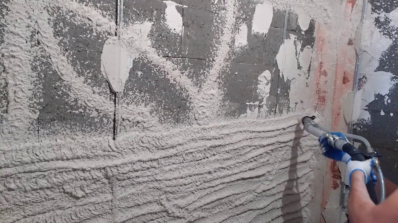 Машинная штукатурка стен. подача смеси на стену штукатурной станцией ...