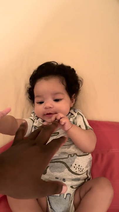 BABY LOOKING AT DAD’s HAND