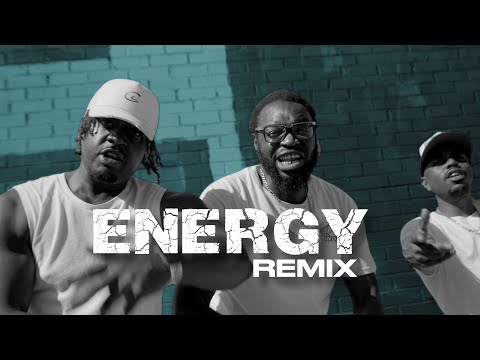 Still from the Energy Remix music video: three performers in front of a teal brick wall under the word ENERGY