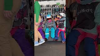 Girl wearing helmet and goggles falls asleep on bench in ski shop then falls forward and faceplants