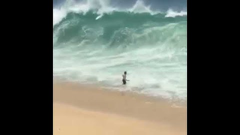 Guy walks into ocean slammed by wave