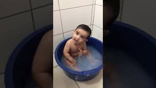 Bebê tomando banho na bacia