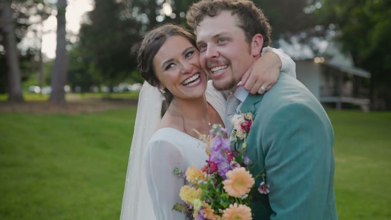 Bride and groom laughing cheek to cheek with a colorful bouquet at Chapman Hill