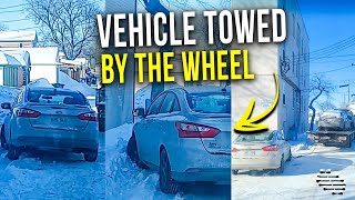 Tow Truck Driver Pulling a Vehicle by the Wheel