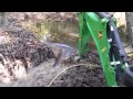 John Deere 1025r digging out a beaver dam