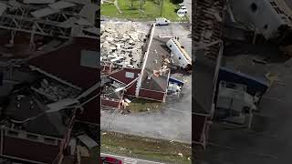 Drone footage shows school bus tossed onto gym from tornado
