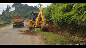 Jcb digging and loading soil into a tipper truck