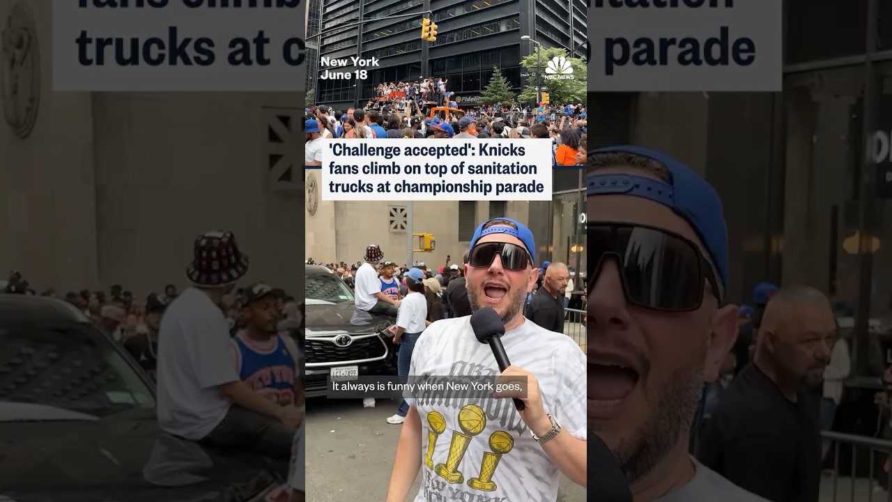 Knicks fans climb on top of NYC sanitation trucks parked outside the championship parade route