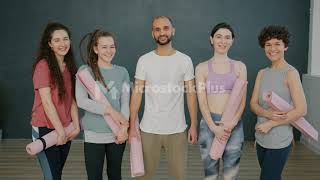 Portrait of yoga group male and female smiling standing in gym together