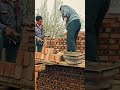stacking red bricks and spreading mortar evenly while building a strong wall structure on site area