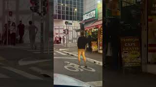 Dog Rides On Shoulder Through Busy Sao Paulo Street
