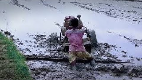 power tiller trapped in deep mud. small boy rescue it with his technique
