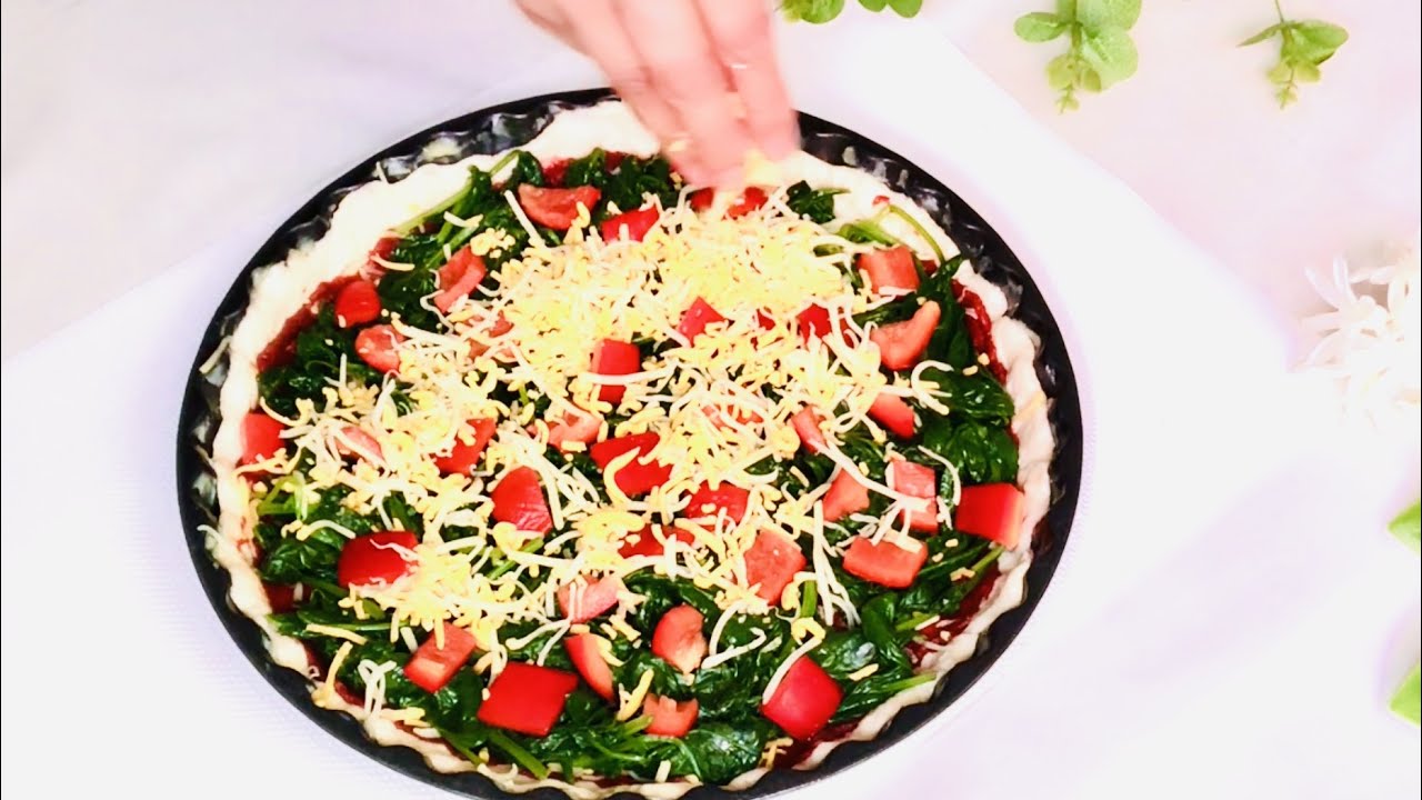 Köstliche hausgemachte vegetarische Pizza mit Spinat und Paprika: Ein Geschmackserlebnis.
