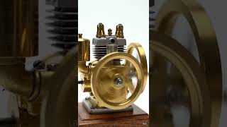 miniature brass internal combustion engine on a polished wooden base, set against a