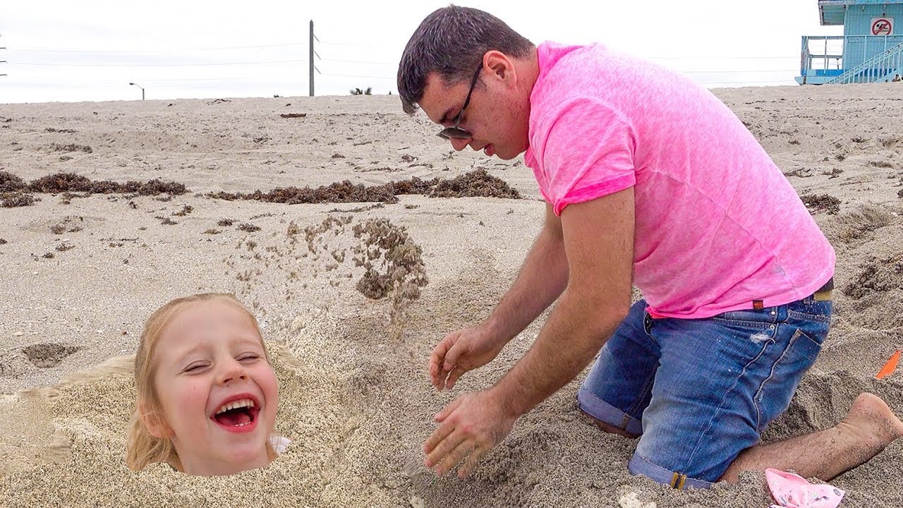 Stacy e papai brincam no mar na areia