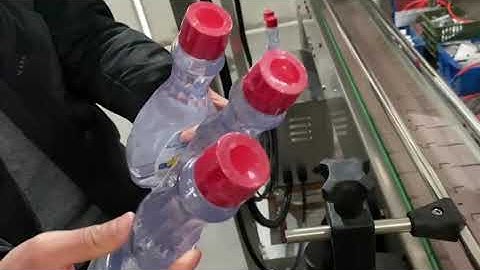 Semi-automatic shrink sleeve machine for bottle caps tamper evidence.