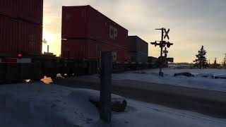 CP stack and freight train with a BNSF ES44AC at middle leaving Ogden yard Calgary.