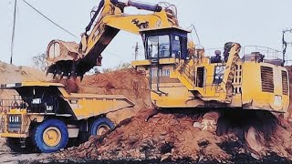 cat 6030b excavator digging loading red soil into cat 777 truck