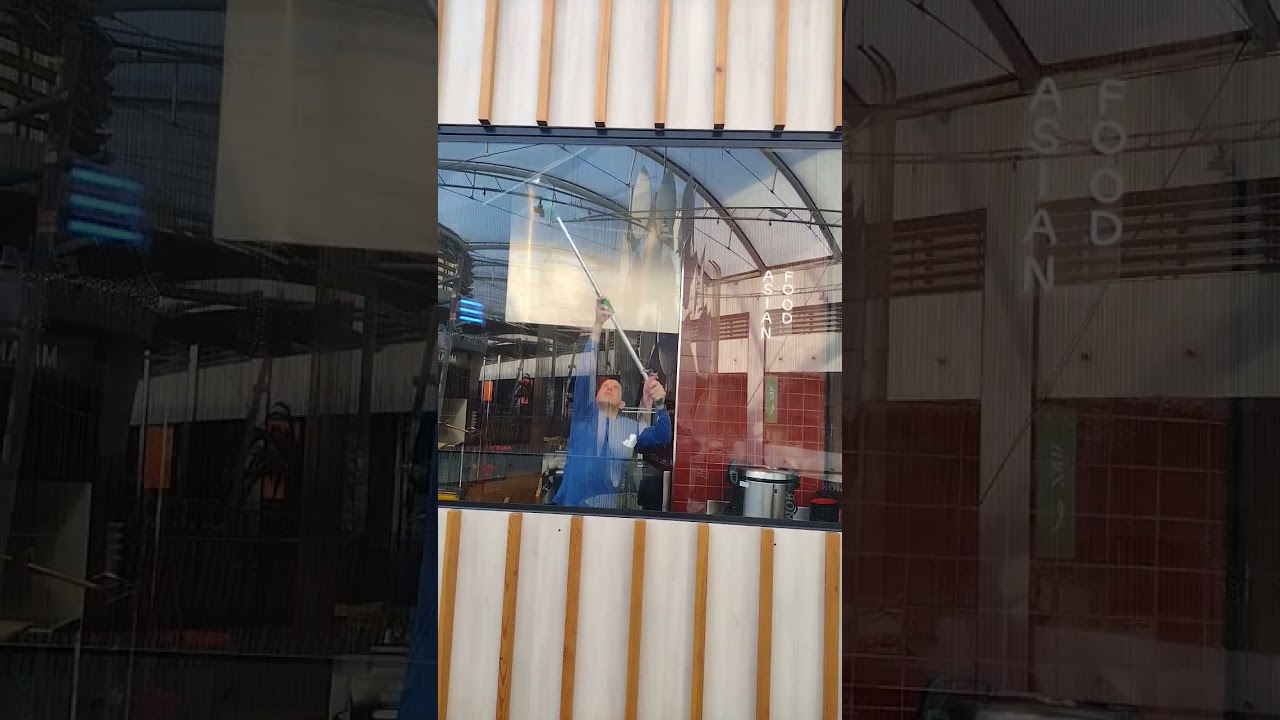 Limpieza de los cristales de un local en un centro comercial de Madrid