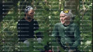 Two men tourists having a rest sitting in forest and talking each other.