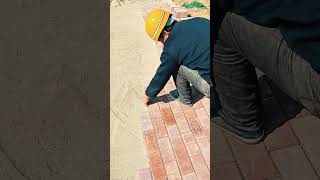 installing orange paving bricks neatly on the sand ground at the construction site area