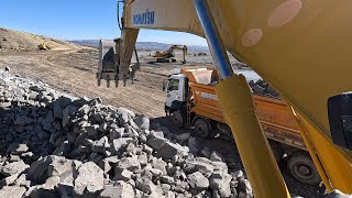 Komatsu Excavator Loading stones onto trucks