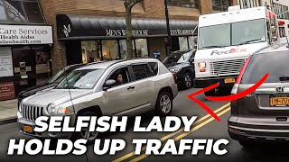 Selfish lady holds up traffic for 2 blocks because she won't move her double parked car