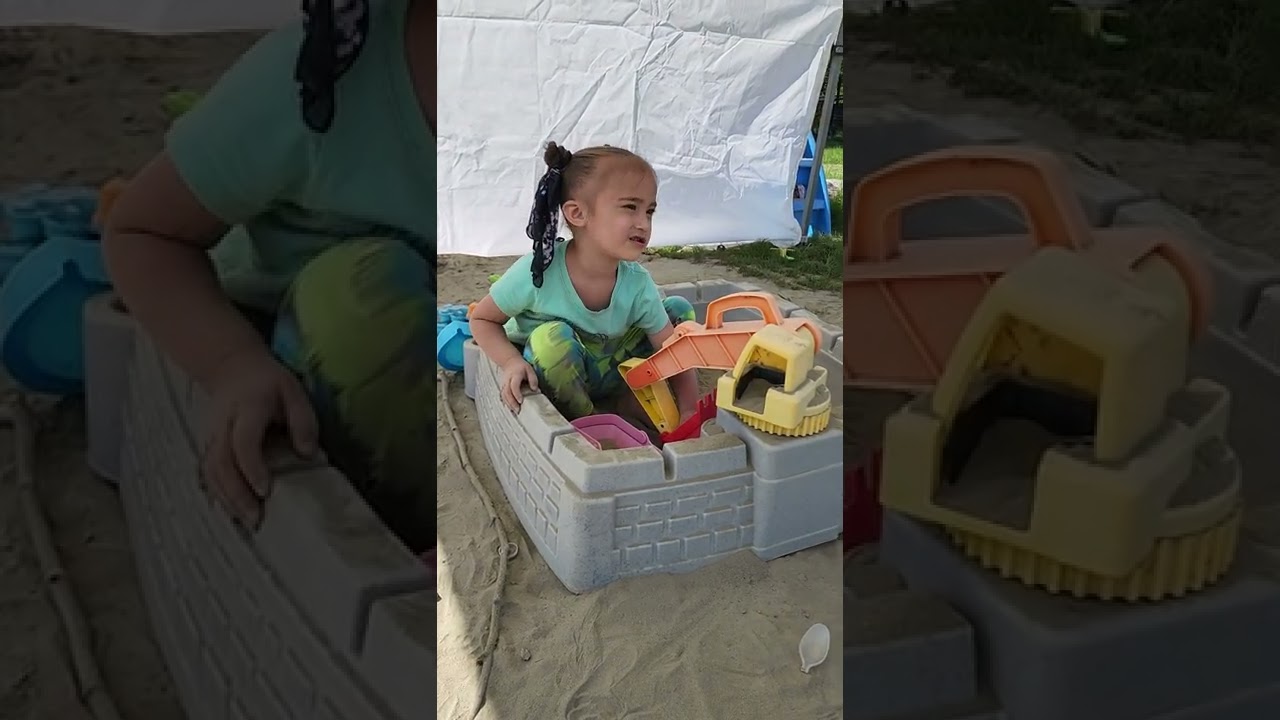 CUTE 3 YEAR OLD GIRL PLAYING IN THE SANDBOX 