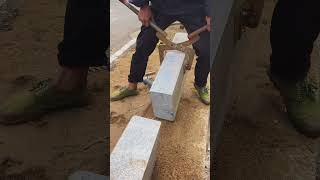 Construction workers laying curb stones, the embodiment of a strong man