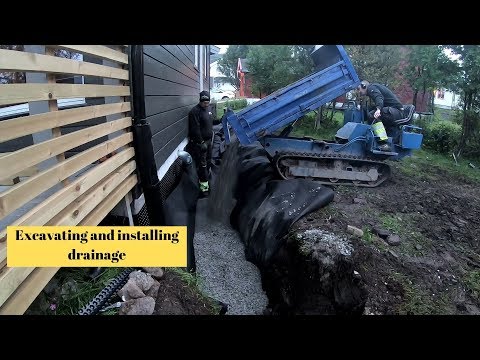 Excavating and installing drainage on house