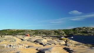 Small Red House On Cliffs Near Coast In Bohuslän - Waves Crashing Against Cliffs