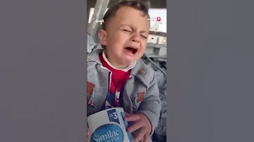 طفل فلسطيني يبكي من الجوع وفي يده عبوة حليب فارغة 