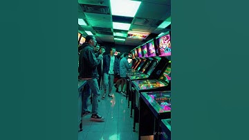 A cinematic walkthrough inside a crowded 2000s arcade game center