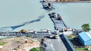 Build a road across the lake Power Machane work dump truck By Wheel Loader Push Stones into Water